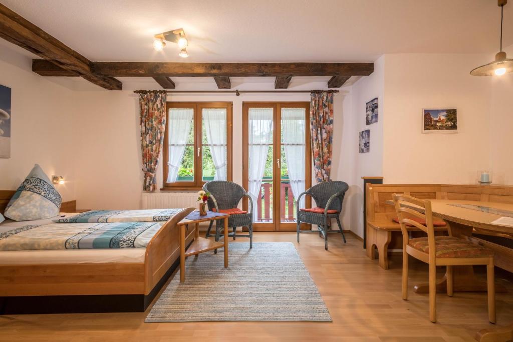 a bedroom with a bed and a desk and a table at Ferienwohnung Risthof 4 in Owingen