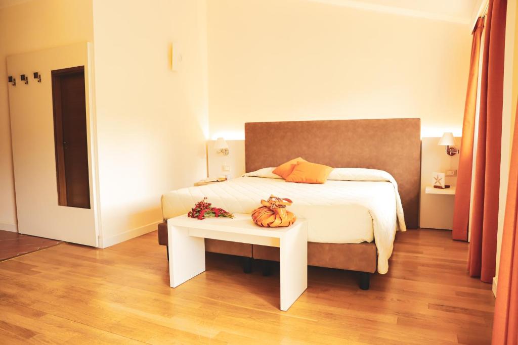 Un dormitorio con una cama y una mesa con calabazas. en Cà Del Moro Resort, en Pontremoli