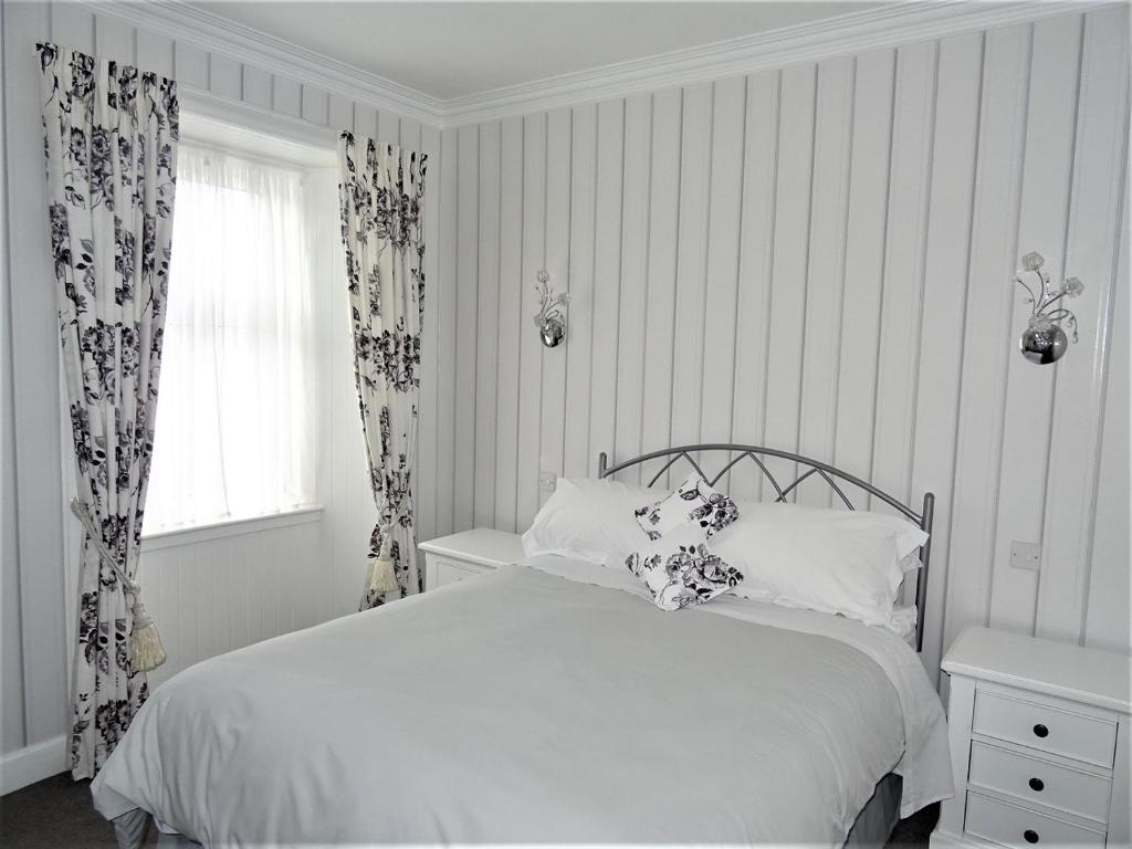 a bedroom with a white bed and a window at Adam Guest House in Perth