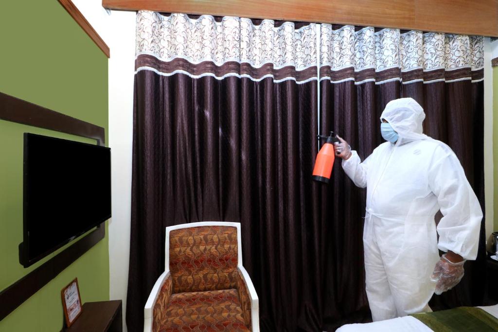 a man dressed in white standing in front of a curtain at Hotel Seven- Center of City Chandigarh in Chandīgarh