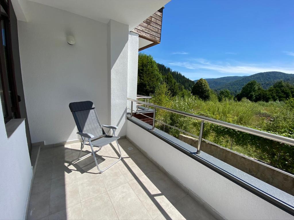 una silla sentada en un balcón con vistas en Luxury Cosmo Apartments Sinaia, en Sinaia