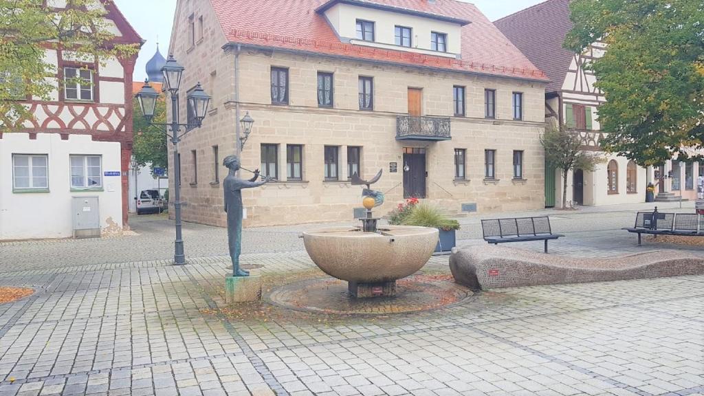 a statue in the middle of a street with a fountain at Ferienwohnung Abel in Heideck