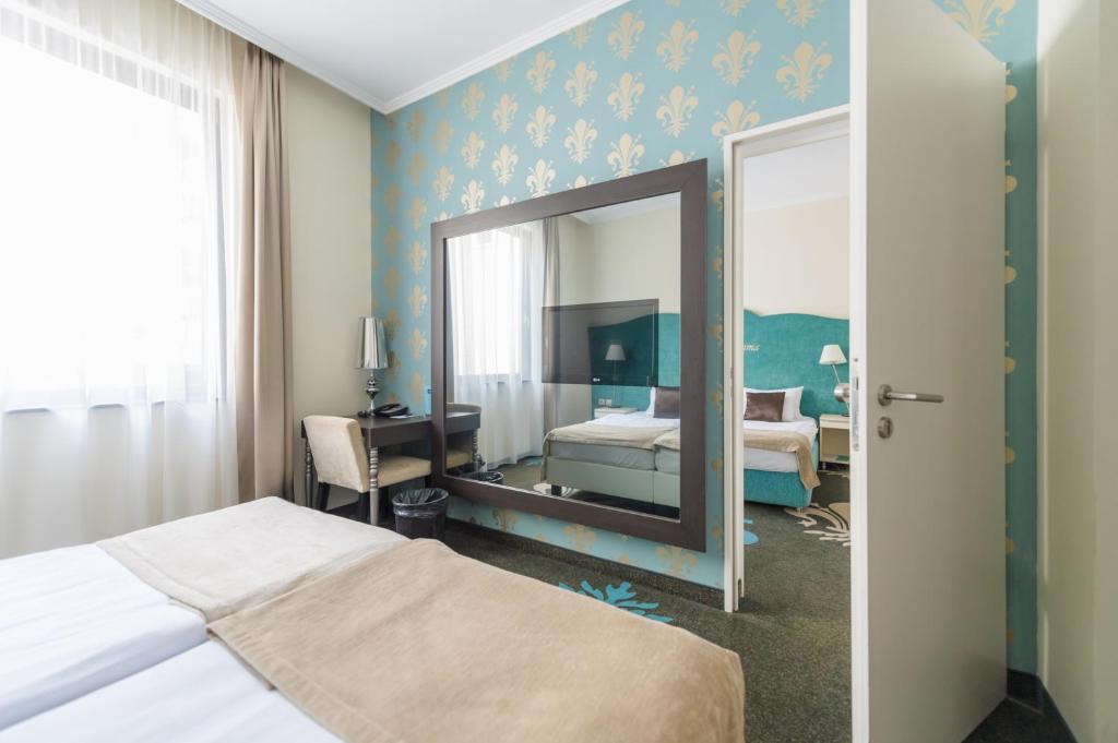 A bed or beds in a room at La Prima Fashion Hotel Budapest