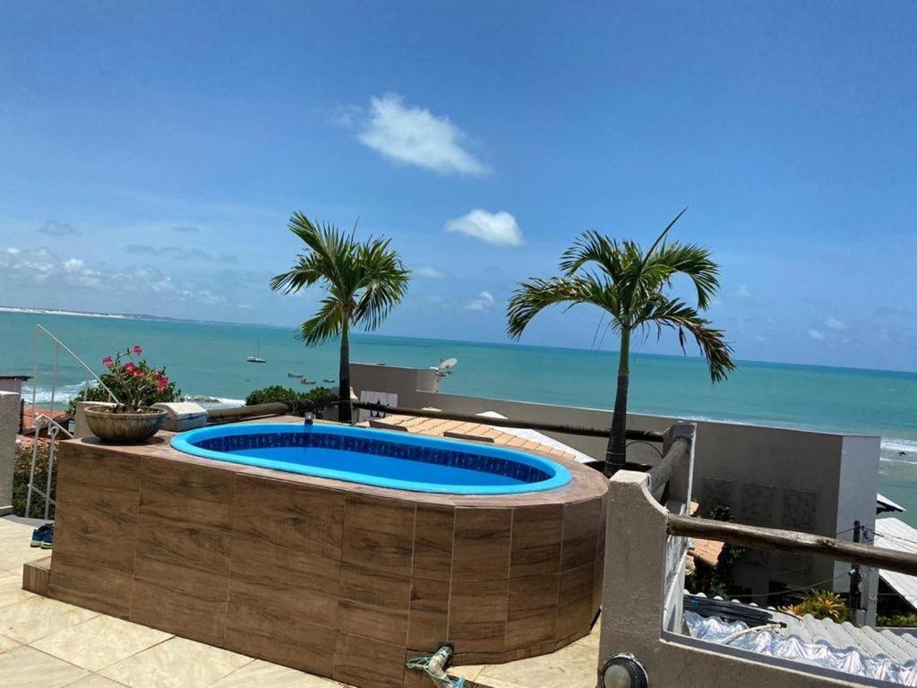 una piscina con el océano en el fondo en Casa Baroni, en Pipa