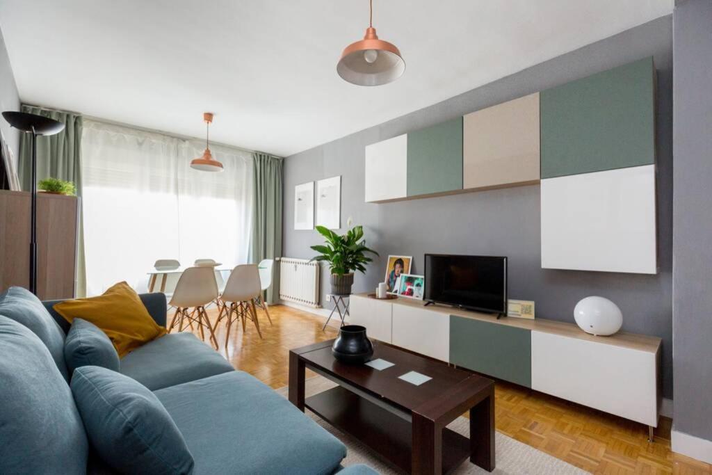 sala de estar con sofá azul y TV en SANTANDER - Apartamento ejectutivo con garaje, en Zaragoza