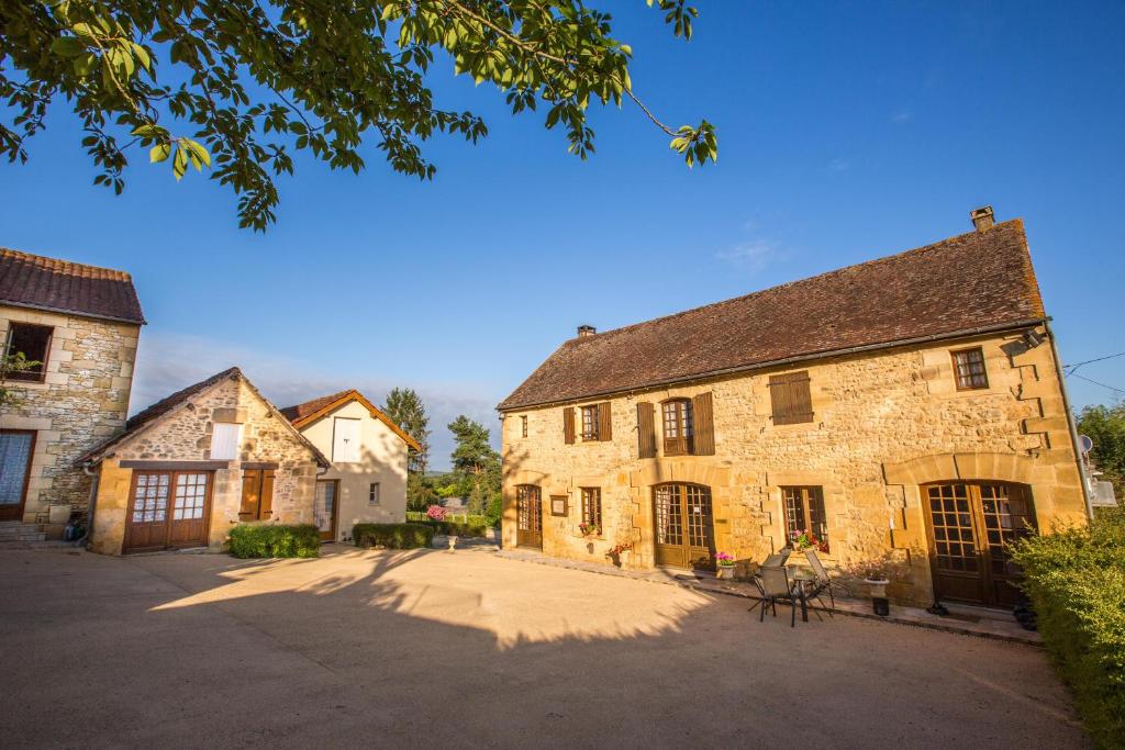 an old stone building with a driveway in front of it at Chambres et table d'hôtes - Domaine de Bardenat in Marquay