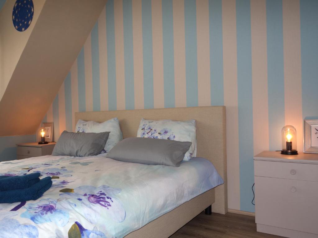 Schlafzimmer mit einem Bett mit blauen und weißen Streifen in der Unterkunft Mosea in Zeltingen-Rachtig