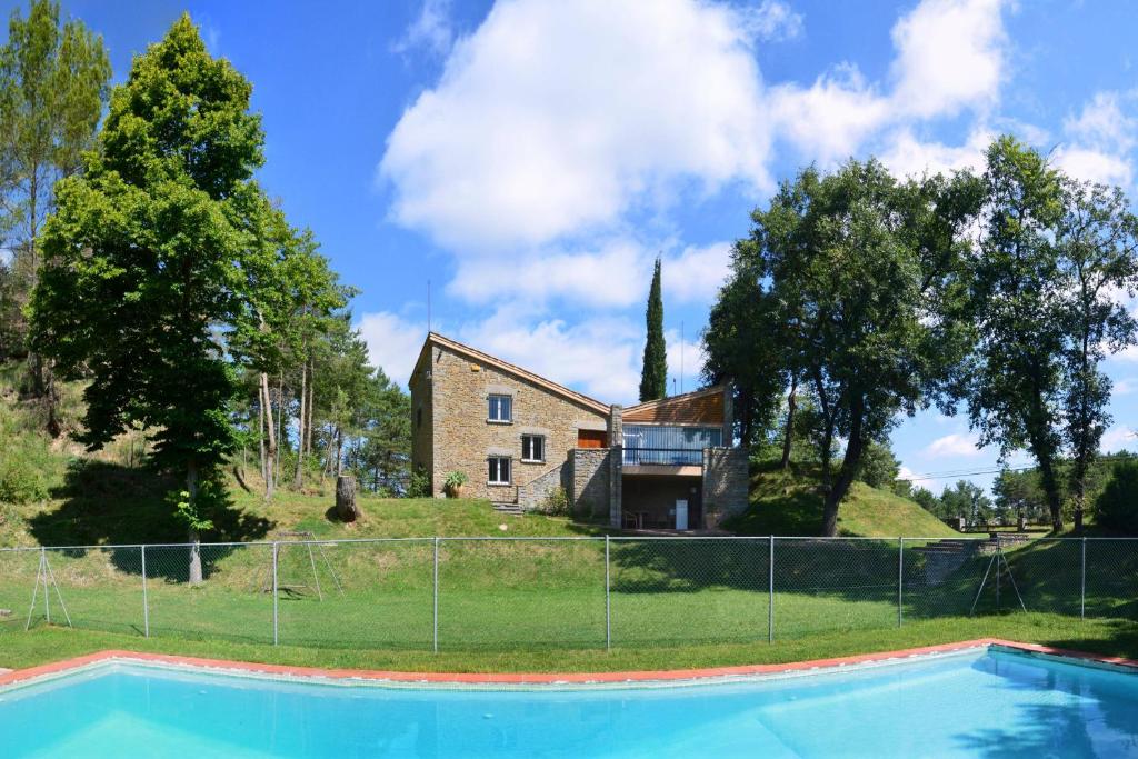 a house with a swimming pool in front of a fence at Refugi del Esquirol in Sobremunt