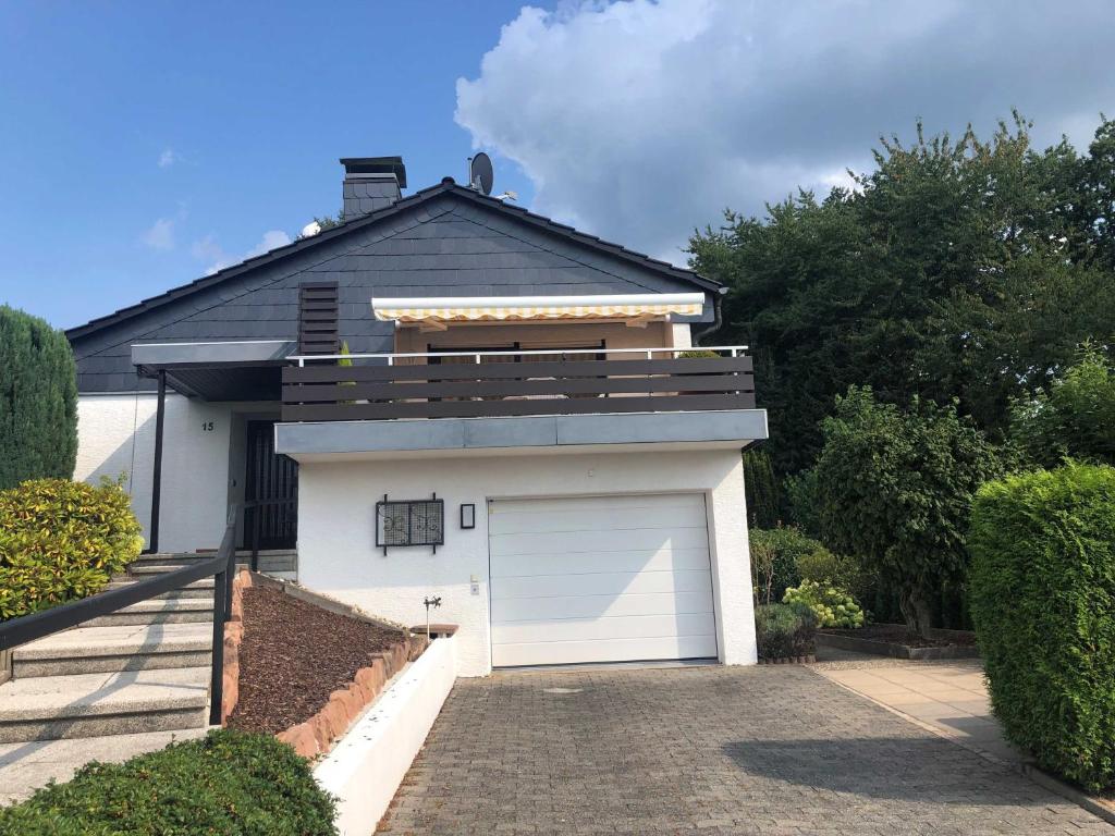 un garaje con una puerta de garaje blanca delante de una casa en Odenwald Chalet en Erbach