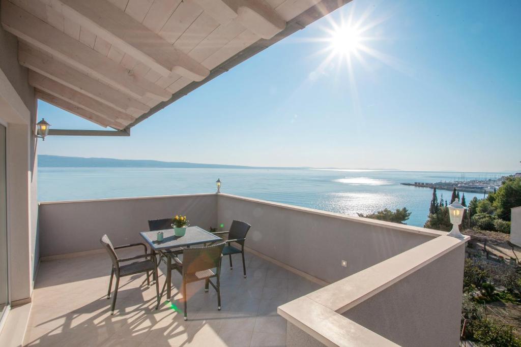 balkon ze stołem i krzesłami oraz oceanem w obiekcie Luxury Sea View Apartment w mieście Jesenice