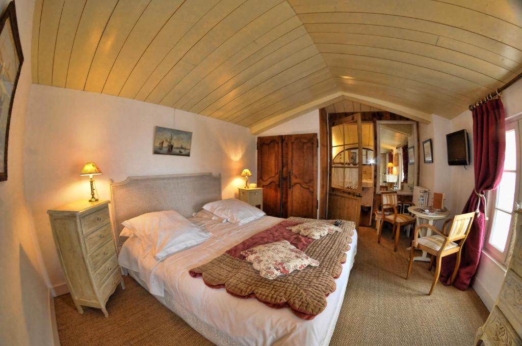 a bedroom with a large bed in a room at Le Corps de Garde in Saint-Martin-de-Ré