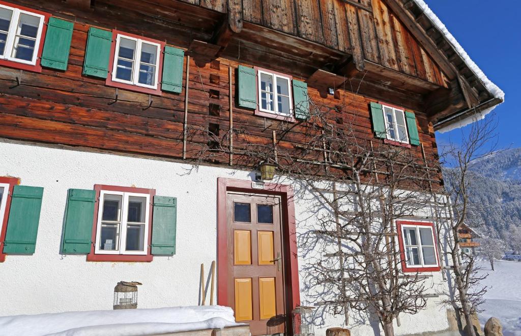 ein Holzhaus mit bunten Türen und Fenstern in der Unterkunft Schwadenguetl in Gosau