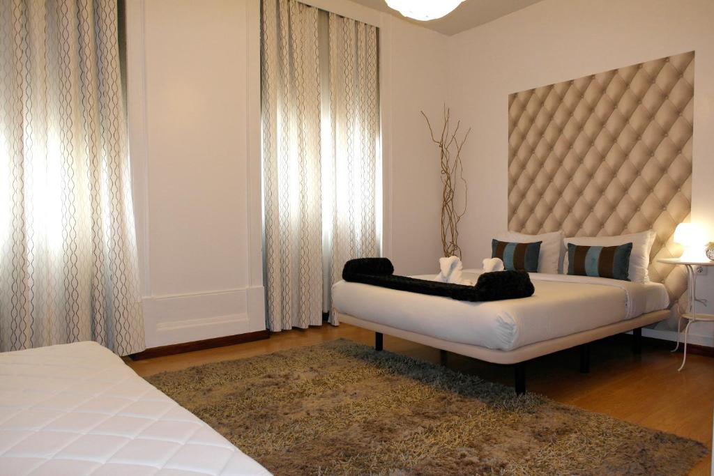 1 dormitorio con cama blanca y ventana grande en Pensao Central, en Matosinhos