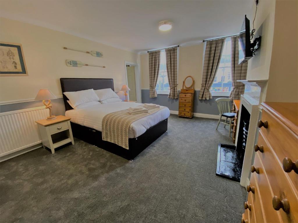 um quarto com uma cama, uma televisão e uma lareira em Katch em Northallerton