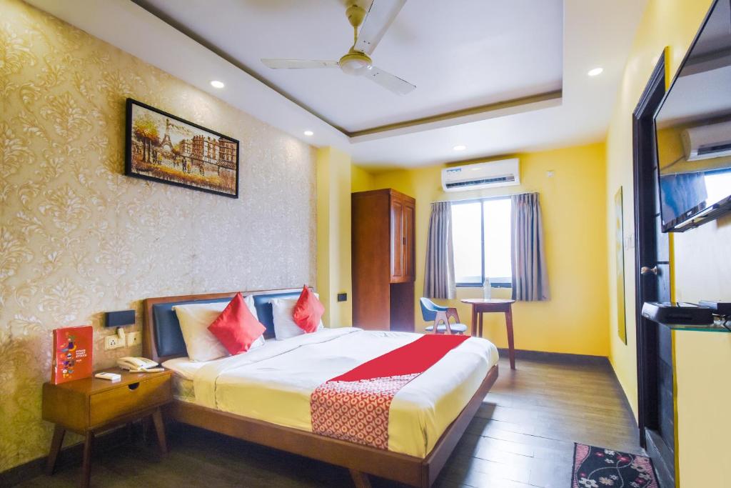 um quarto de hotel com uma cama e uma mesa em Kiaan Inn em Calcutá