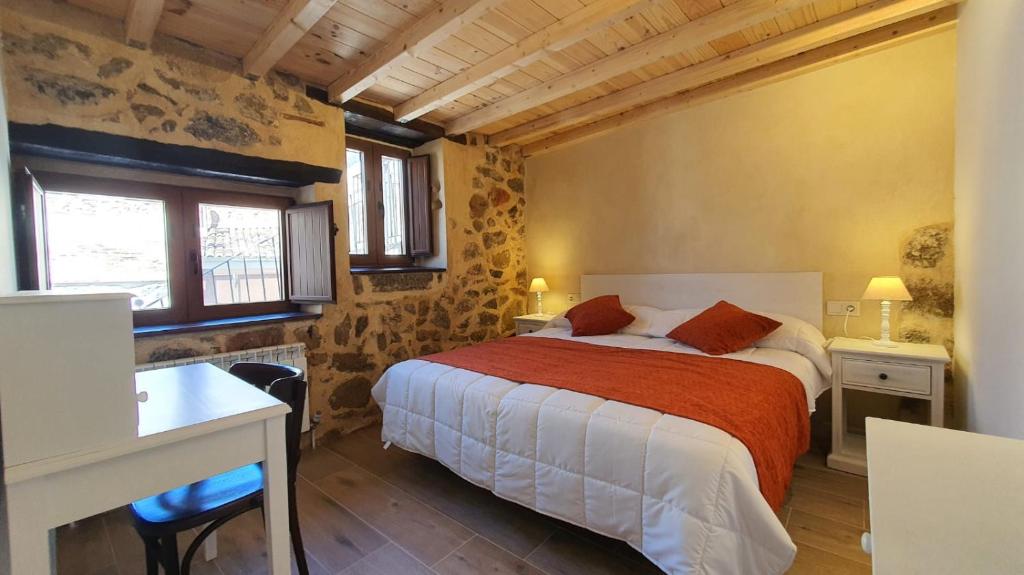 1 dormitorio con 1 cama, escritorio y ventanas en Casas del Castillo, 4, en Ávila