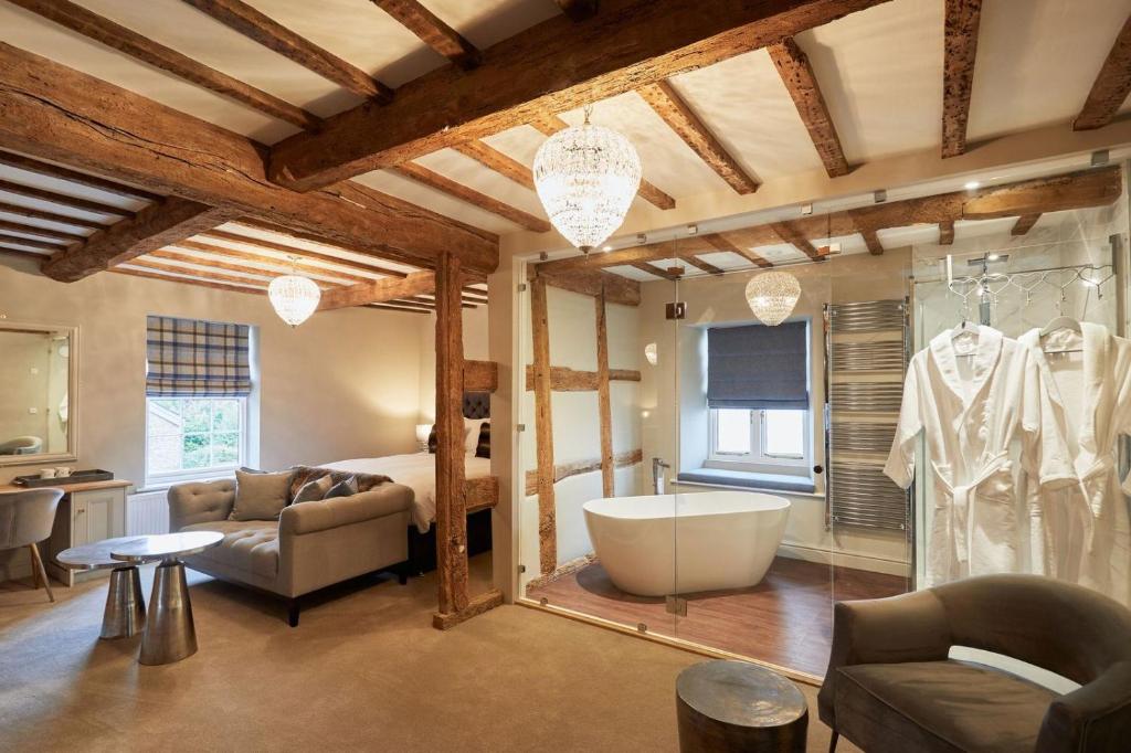 a bathroom with a bath tub and a bedroom at The New Inn in Hereford