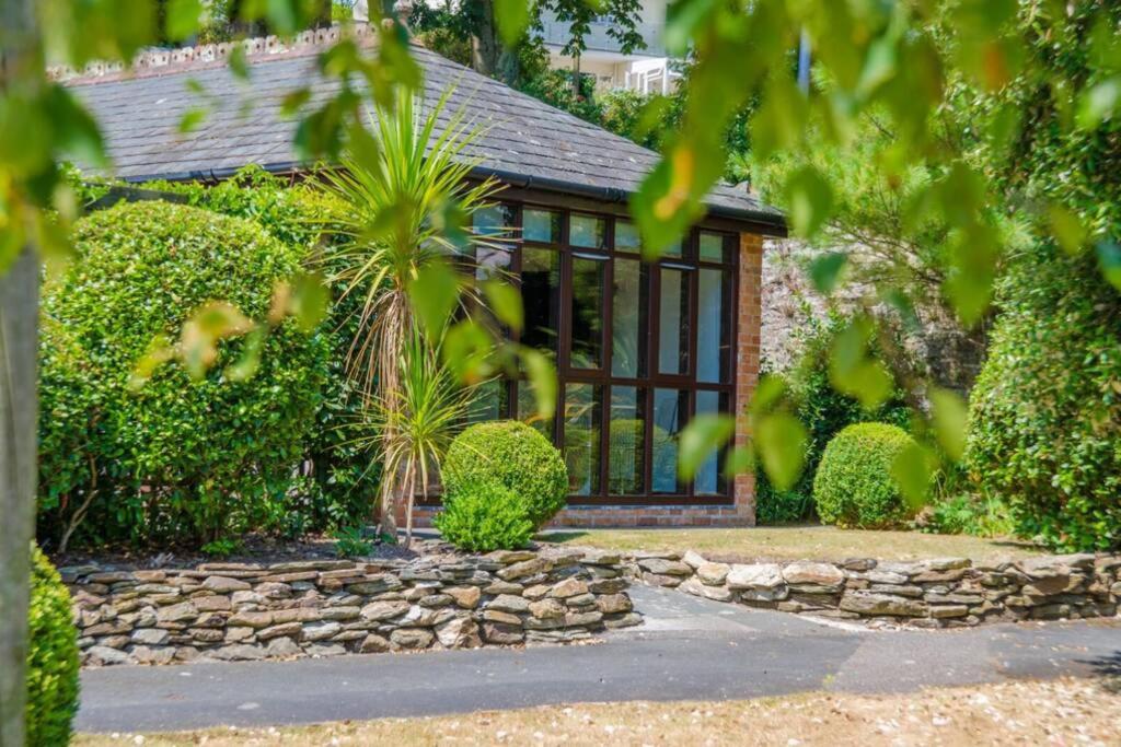 uma casa com uma parede de pedra e uma janela em Luxury Summerhouse Annexe in lush gardens in Fowey em Fowey