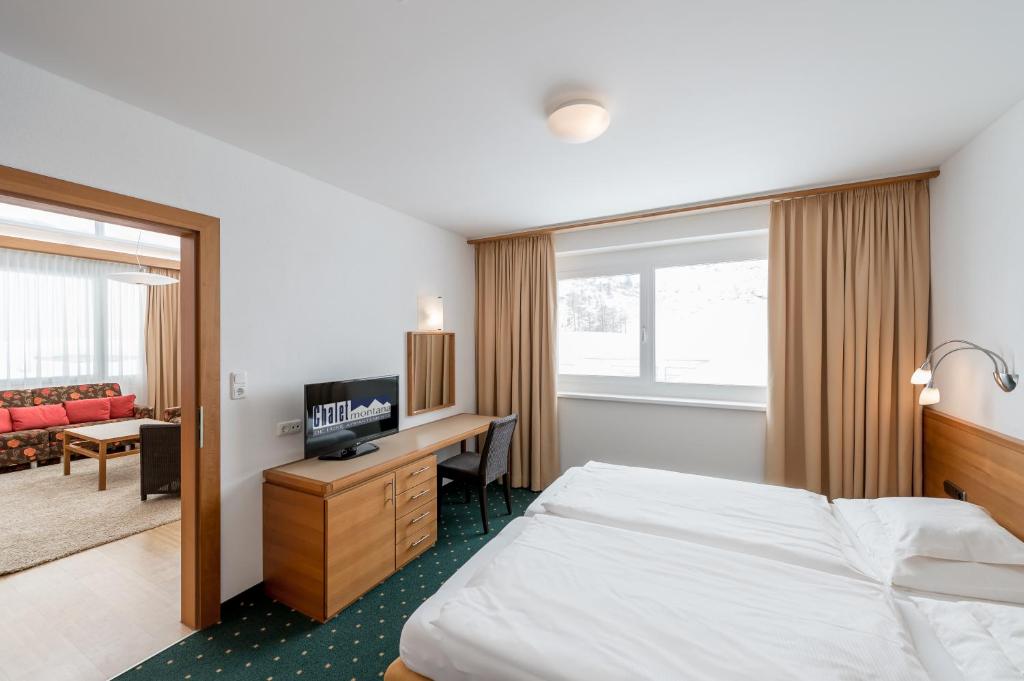 ein Hotelzimmer mit einem Bett und einem Schreibtisch in der Unterkunft Chalet Montana in Obergurgl