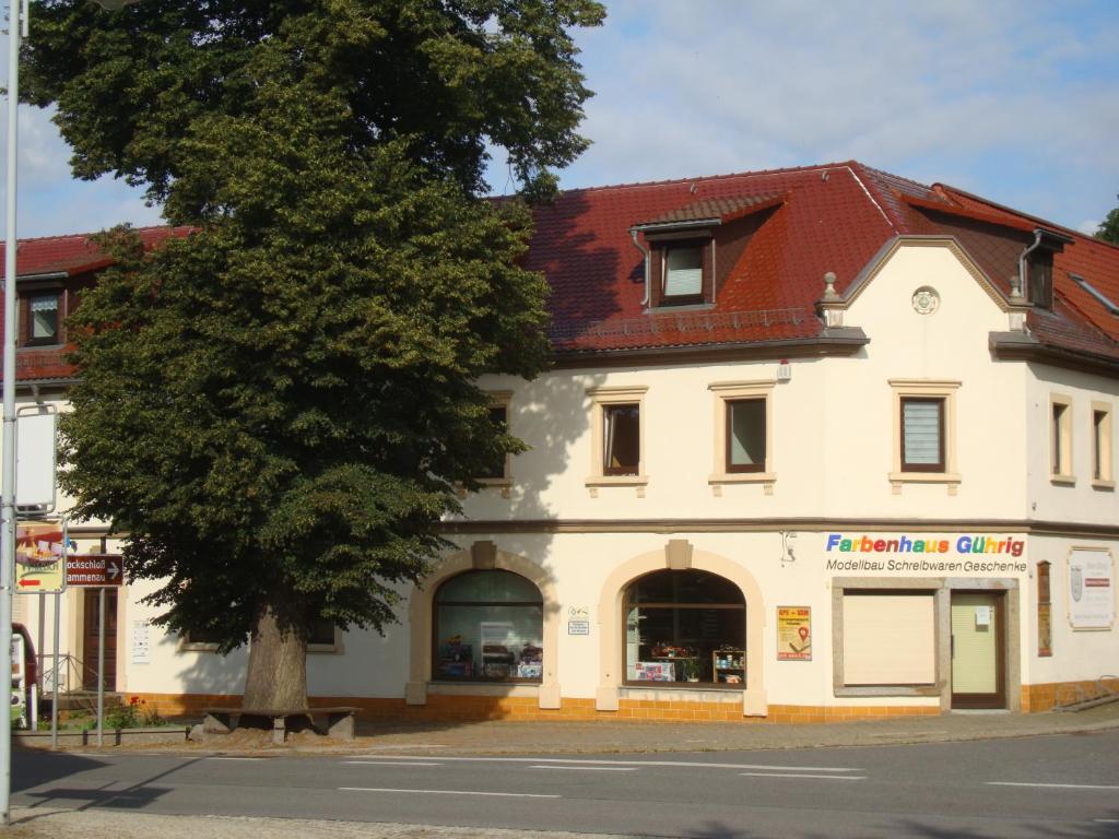 un gran edificio blanco con un árbol delante en Fewo-Rammenau Monteurunterkunft, en Rammenau