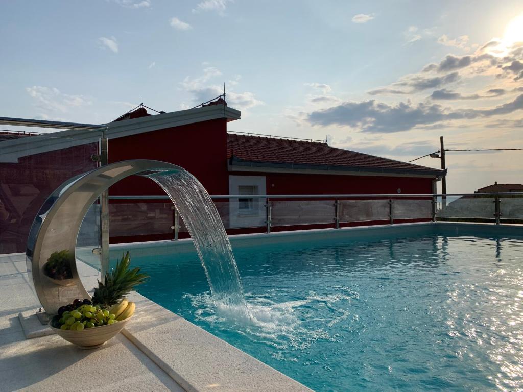 a swimming pool with a water fountain at Stella Maris in Kaštela