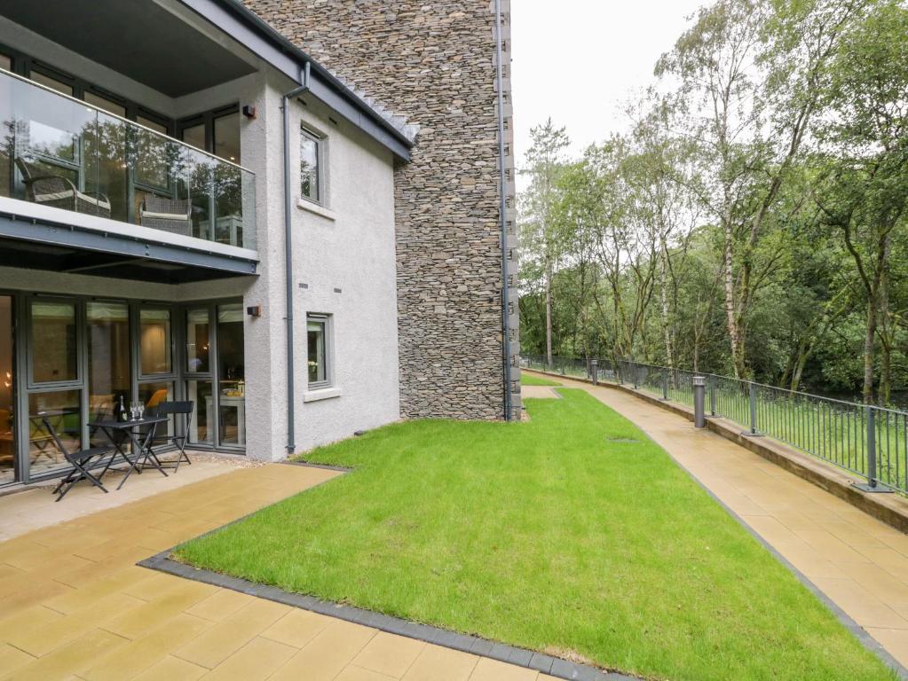 a patio with green grass next to a building at Leven View in Ulverston