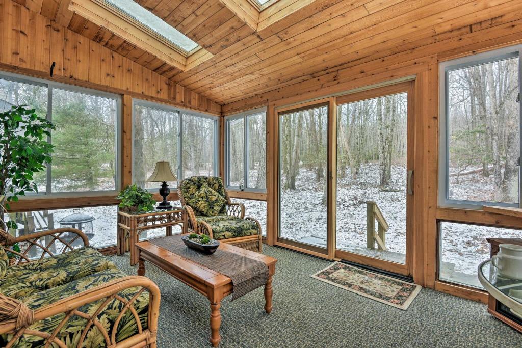a living room with a couch and a table and windows at Lake Harmony Townhome - 1 Mi Big Boulder Ski Area! in Lake Harmony