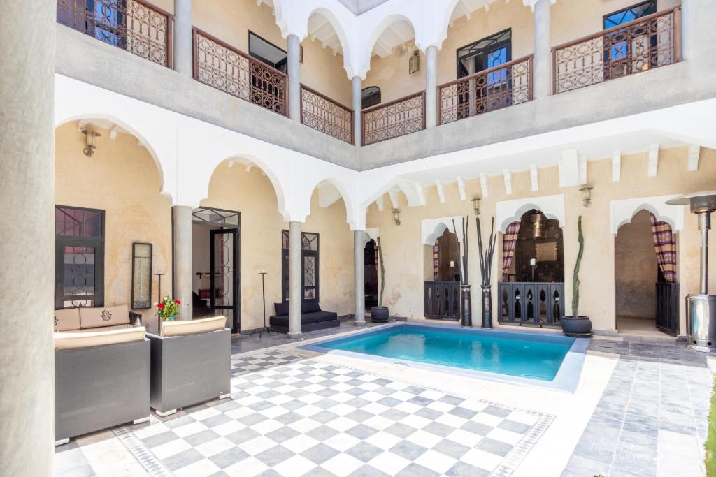 an indoor courtyard with a swimming pool and a building at Riad Dar El Masa in Marrakesh