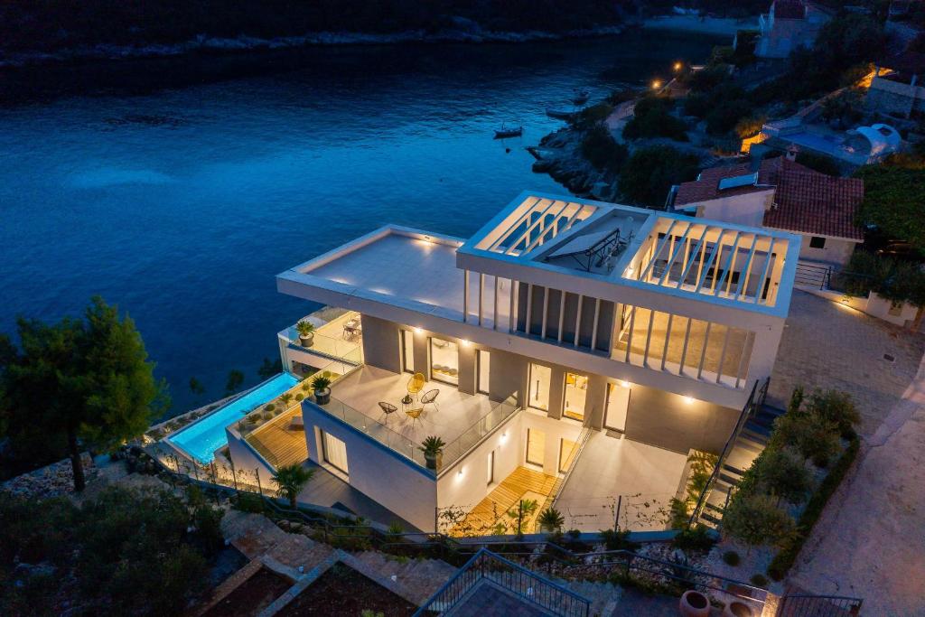 an aerial view of a house with a swimming pool at Beachfront Villa Extravaganza with Infinity Pool in Vinišće