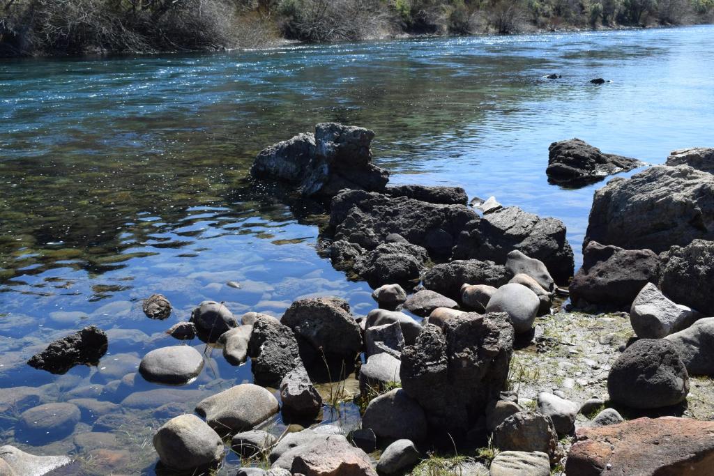 a group of rocks on the side of a river at Montalto in Dina Huapi
