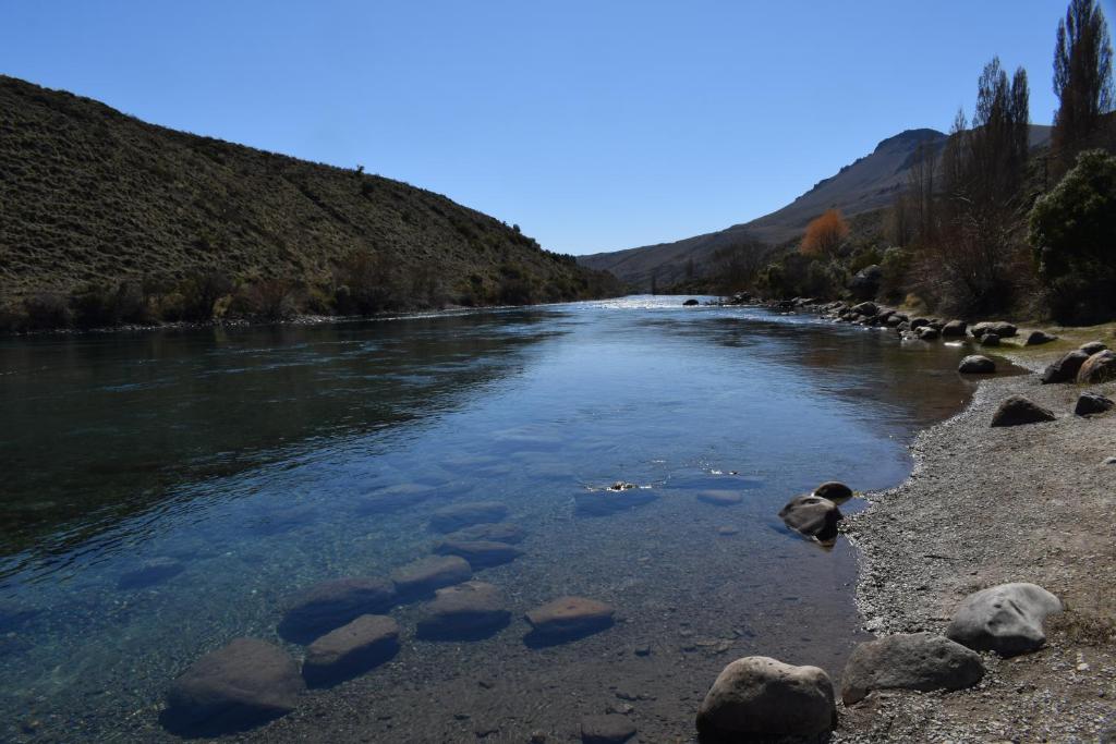 a river with some rocks in the water at Montalto in Dina Huapi