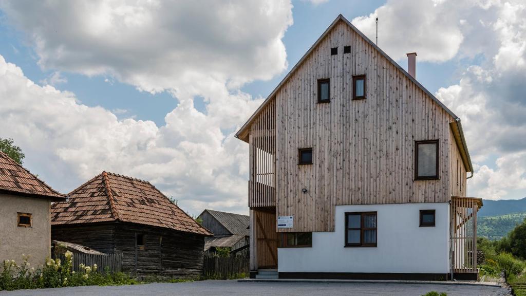 Eine alte Scheune befindet sich neben einem Haus in der Unterkunft Pensiunea Agroturisticā Lukács Panzió in Ujfalù