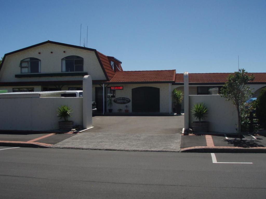 une maison avec un parking en face de celle-ci dans l'établissement Manfeild Park Motel, à Feilding