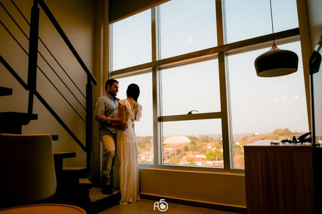a woman standing in front of a window looking out at Hotel Le Pelican in Asunción