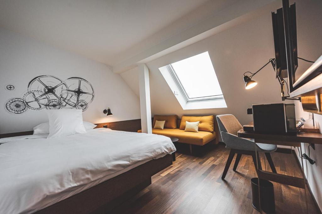 a bedroom with a bed and a desk at Hotel Bernina Geneva in Geneva