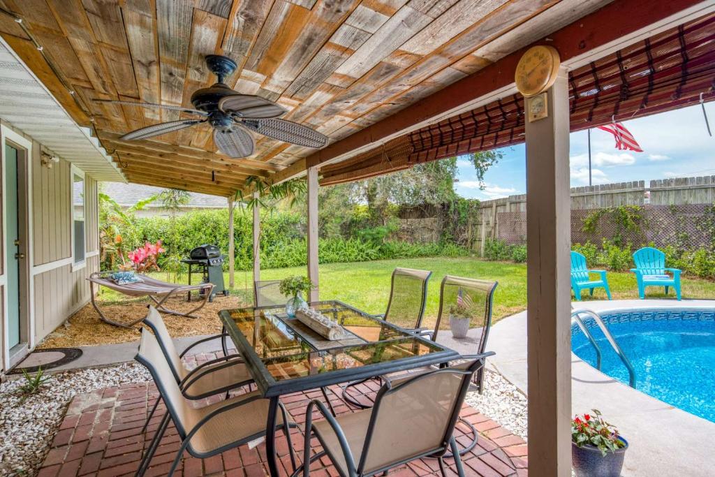 une terrasse avec une table, des chaises et une piscine dans l'établissement Gathering Shore, à Saint Augustine