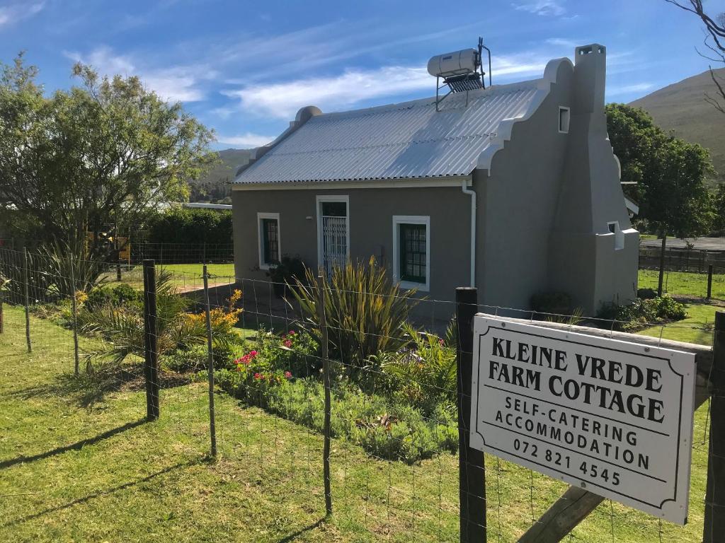 a sign in front of a farm cottage at Kleine Vrede Farm Cottage in Hermanus