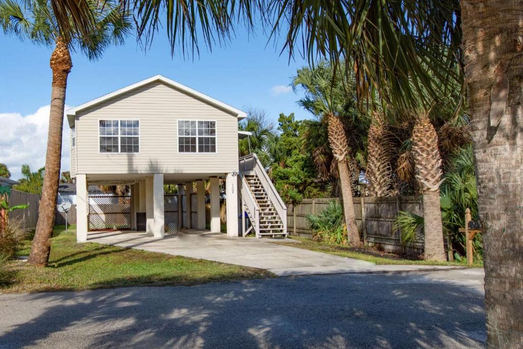 a white house with palm trees in front of it at 102 10th St. in Saint Augustine Beach