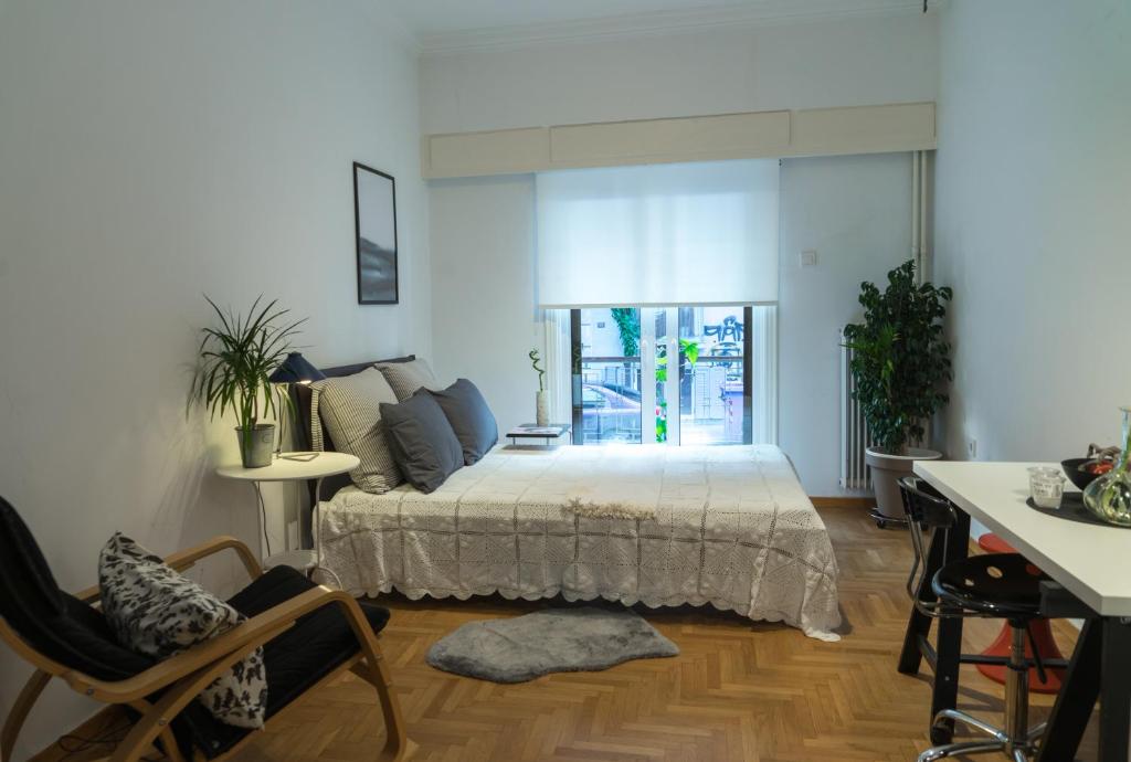 a bedroom with a bed and a table and chairs at Comfy studio apartment very close to city centre in Athens