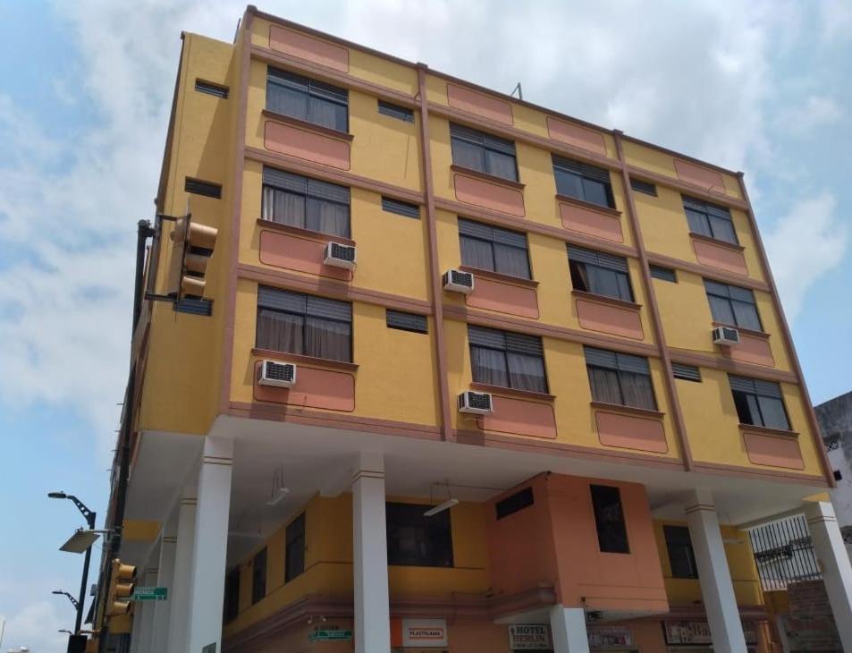 un edificio amarillo con ventanas en la parte superior en Hotel Berlín, en Guayaquil