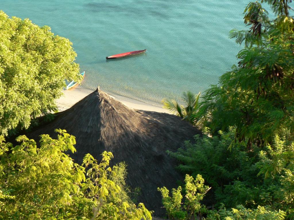 vistas a una playa con un barco en el agua en Waecicu Eden Beach Hotel, en Labuan Bajo