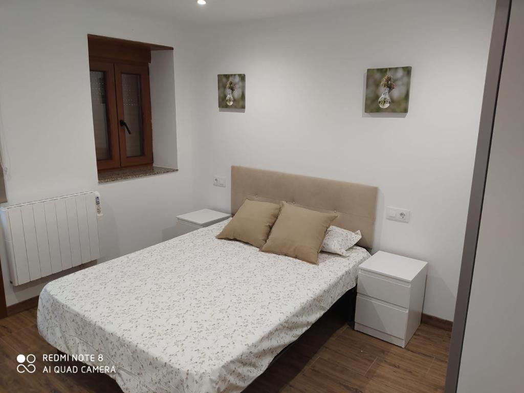 sypialnia z łóżkiem z białą pościelą i poduszkami w obiekcie EL MEJICANO II w mieście Trevías
