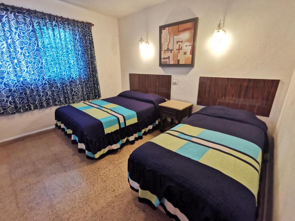 Postel nebo postele na pokoji v ubytování Hotel Las Dalias Inn