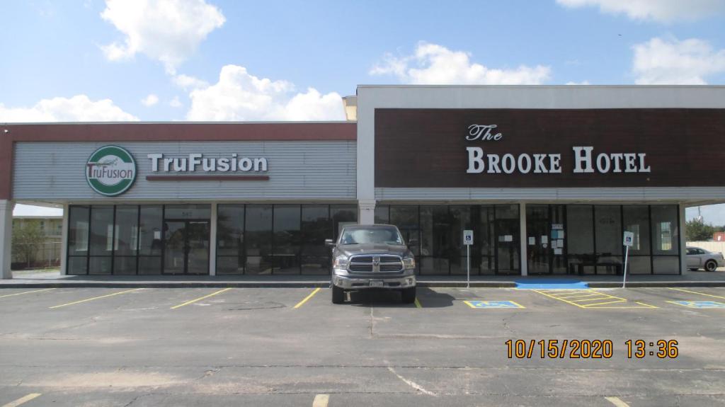 a car parked in a parking lot in front of a store at The Brooke Hotel in Brookshire