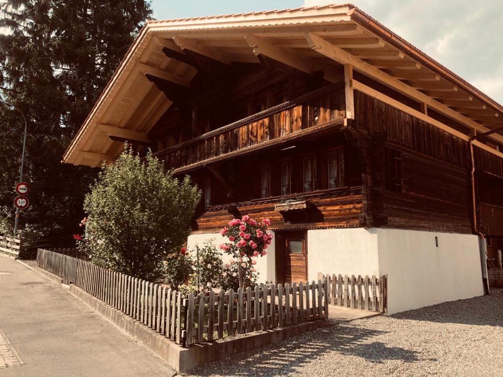 una casa in legno con una recinzione di fronte ad essa di Gemütliches Zuhause mit Ausblick a Wilderswil