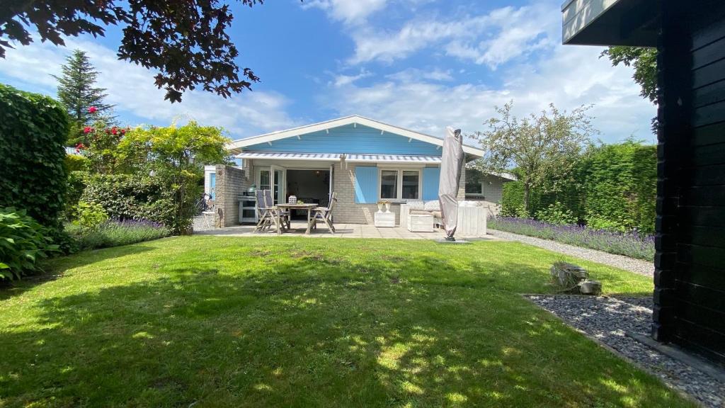 ein kleines blaues Haus mit Garten in der Unterkunft Zee en Meer in Kamperland