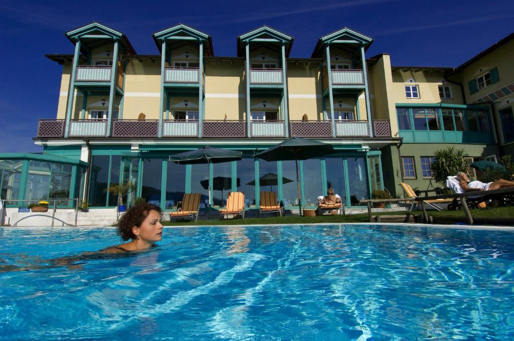 a woman in a swimming pool in a hotel at das kappel wein gut hotel in Kitzeck im Sausal