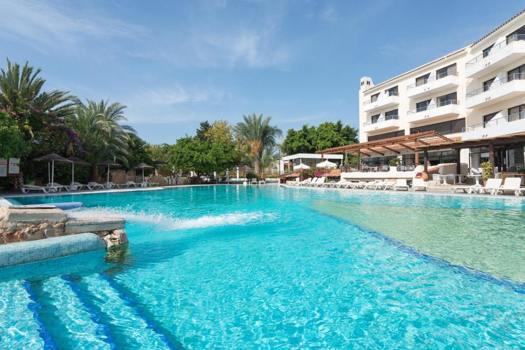 a swimming pool in front of a hotel at Paphos Gardens Holiday Resort in Paphos City