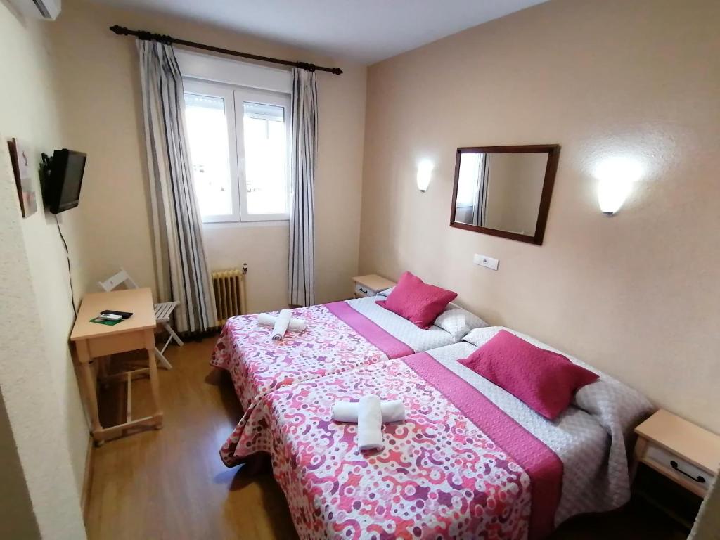 A bed or beds in a room at Hostal Hernan Cortes