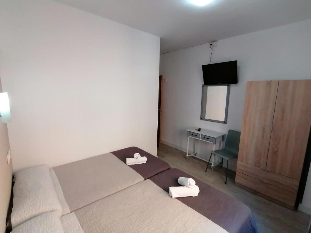 A bed or beds in a room at Hostal Hernan Cortes